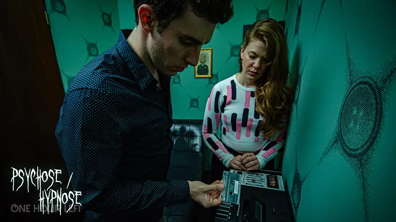 Two players working on a puzzle console together in an escape room.