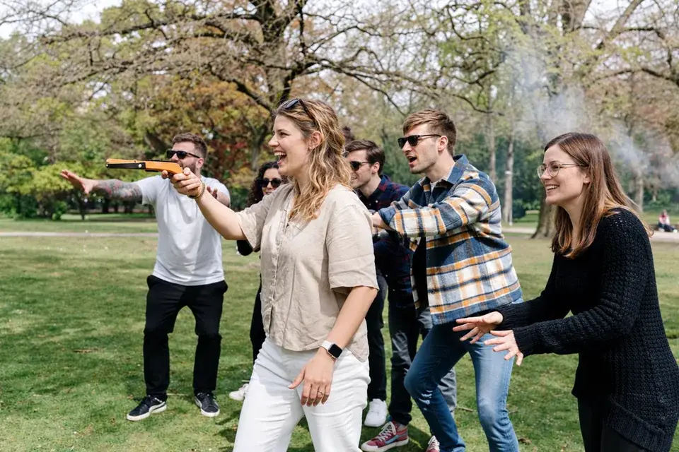 Eine Spielerin zielt mit der Mini-Armbrust, ihr Team fiebert mit